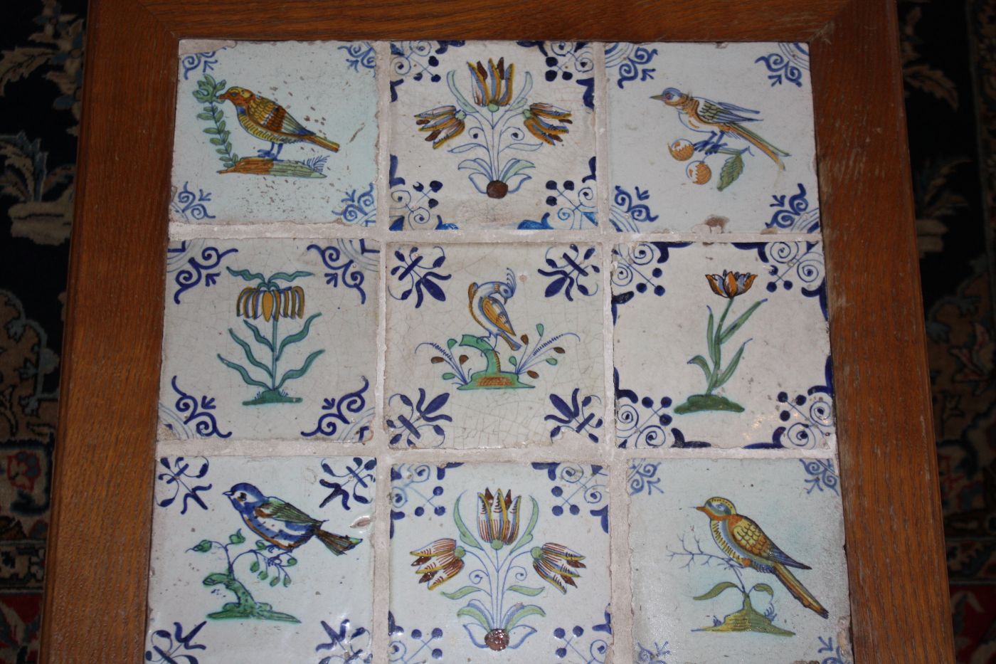 Tisch mit 9 antiken, polychromen Delfter Fliesen, 5 Vogel-,  4 Blumenmotive, 1. Hälfte 17. Jh., Maße Tisch: Höhe 41 cm, Breite 52,5 cm